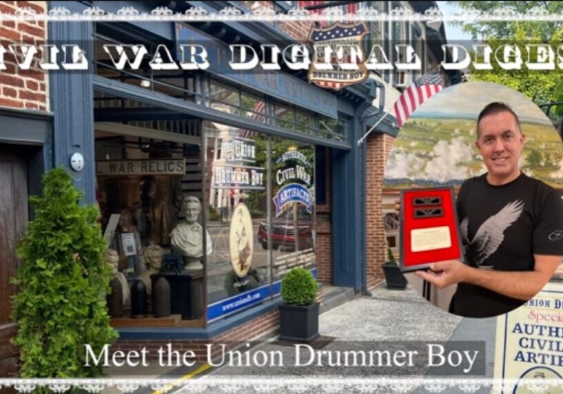 A man holding a plaque stands outside a store called Civil War Digital Digest, which displays Civil War memorabilia and American flags. Text reads: “Meet the Union Drummer Boy.”.