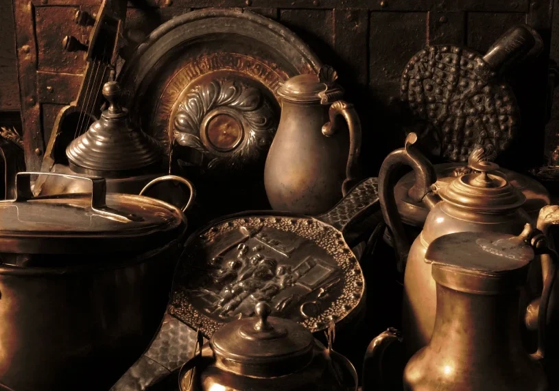 A group of antique pots and pans on display.